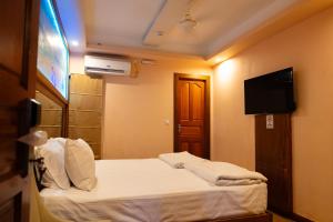 a hotel room with a bed and a flat screen tv at Six In Lodge in Male City +8 photos