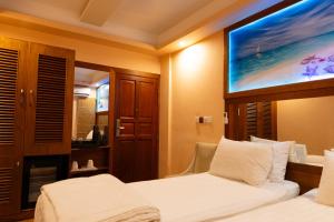 a hotel room with two beds and a flat screen tv at Six In Lodge in Male City