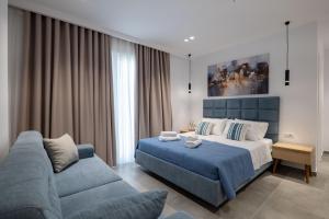 a bedroom with a blue bed and a couch at Vila Antonio in Ksamil +76 photos