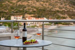 a table with two glasses of wine and a plate of grapes at eu Τhea Apt Samos - Sandy Beach & Amazing View in Psili Ammos