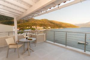 a balcony with a table and chairs and a view of the water at eu Τhea Apt Samos - Sandy Beach & Amazing View in Psili Ammos