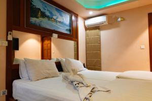 a bedroom with two beds and a tv on the wall at Six In Lodge in Male City