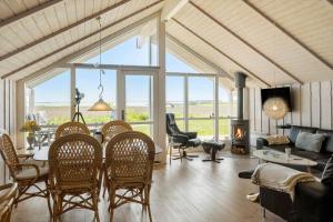 a living room with a table and chairs and a fireplace at LF10209-Thyholm-Markvejen-9 in Thyholm