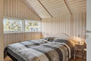 a bedroom with a bed and two windows at LF10209-Thyholm-Markvejen-9 in Thyholm