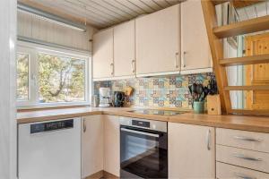 a kitchen with white cabinets and a stove top oven at 0142-Romo-Ivigtut-1 in Høm