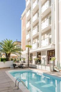 a swimming pool in front of a building at Litoraneo Suite Hotel in Rimini