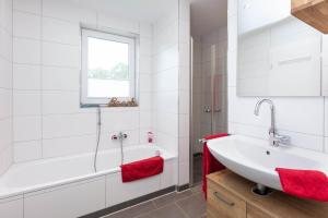 a bathroom with a white tub and a sink at Haus 21 am See in Schüttorf +15 photos
