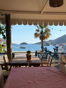 a table with chairs and a view of the ocean at KAJU ROOMS Bozburun in Bozburun