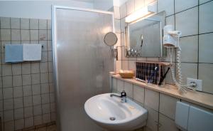 a bathroom with a sink and a mirror at Logis Hôtel-Restaurant Auberge Du Mehrbachel in Saint-Amarin +41 photos