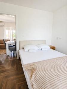 a bedroom with a large white bed and a table at Danube Panorama House - River View, Jacuzzi & Nature in Čelarevo
