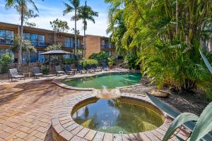 a swimming pool with a fountain in front of a building at Charming Suite Easy Access 2 CBD by Custom Bnb Hosting in Brisbane
