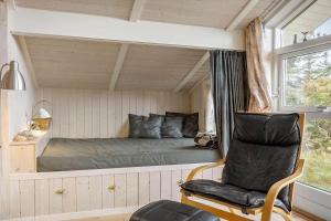 a bedroom with a bed and a chair and a window at LF694-Hurup-Thy-Haettemagevej-8 in Sindrup