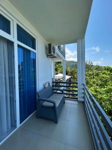 a balcony with a blue couch and windows at Kolkhi Guest House in Gonio