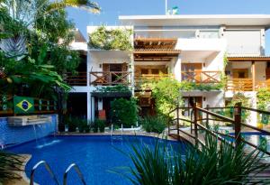 a hotel with a swimming pool in front of a building at Pousada Windjeri in Jericoacoara