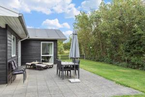 a patio with an umbrella and a table and chairs at LF338-Vestervig-Gunhildsvej-38 in Vestervig