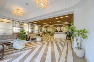 a lobby with tables and plants in a building at Hotel Meera Palace in Varanasi +123 photos