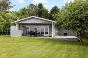 a small house with a porch with a table at LF11101-Struer-Blabaervej-12 in Struer