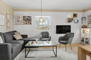 a living room with a couch and a table and chairs at LF11101-Struer-Blabaervej-12 in Struer