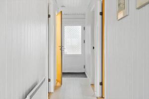 a hallway with white walls and a yellow door at LF11101-Struer-Blabaervej-12 in Struer