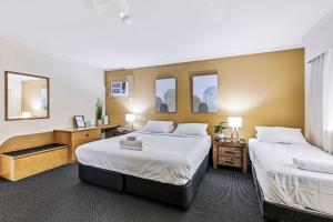 a hotel room with two beds and a desk at Charming Suite Easy Access 2 CBD by Custom Bnb Hosting in Brisbane