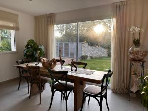 a dining room table with chairs and a large window at A MUREDDA in Bonifacio