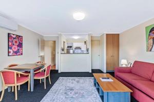 a living room with a red couch and a table at Charming Suite Easy Access 2 CBD by Custom Bnb Hosting in Brisbane