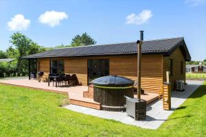 a large wooden cabin with a grill in the yard at LF143-Vestervig-Gunhildsvej-43 in Vestervig