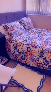 a bed with a floral comforter in a room at 32 Hatton Guest House in Milton Keynes +8 photos