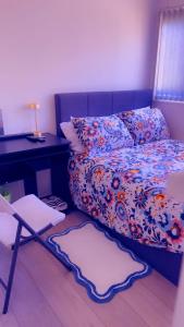 a bedroom with a bed and a desk and a chair at 32 Hatton Guest House in Milton Keynes