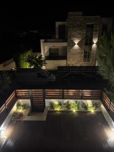 a backyard at night with a fence and lights at Olea Luxury Living in Nea Fokea