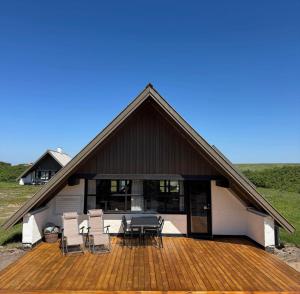 a house with a deck with chairs and a table at 530-Lemvig-Lokkevej-59-D in Lemvig