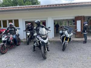 three people on motorcycles parked in front of a building at Rockin 70's Lodges in Barbey-Séroux