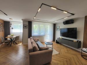 a living room with a couch and a flat screen tv at Apartament Skansen - Sanok in Sanok