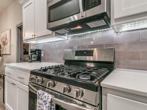 a kitchen with a stove and a microwave at Your Unforgettable Temporary Haven! in Edmond +19 photos