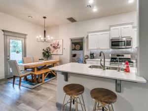 a kitchen with a sink and two bar stools at Your Unforgettable Temporary Haven! in Edmond
