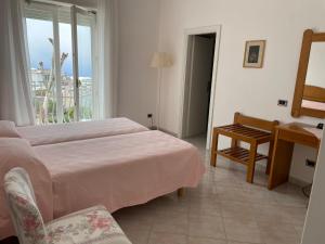 a bedroom with a bed and a desk and a window at Hotel Biancamaria in Anacapri +43 photos