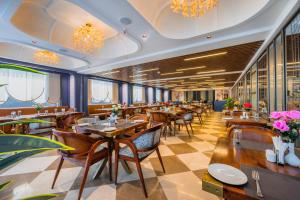 a restaurant with wooden tables and chairs and flowers at Hotel Meera Palace in Varanasi