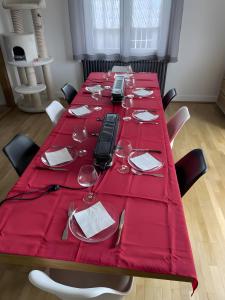a table with a red table cloth on top of it at Chambres d'hôtes d'Isa in Bugeat