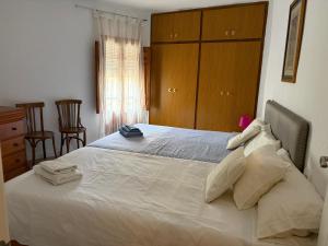a bedroom with a large bed with two towels on it at Casa Emilia in Talayuelas