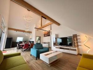 a living room with a couch and a tv at Ferienwohnanlage Einzigartig in Saarburg