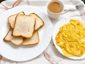 two plates of eggs and toast and a cup of coffee at Ali Baba Hostel & Homestay in Jaipur