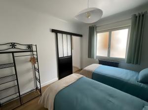a bedroom with two beds and a window at Chambres d'hôtes d'Isa in Bugeat