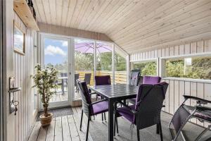 a dining room with a table and purple chairs at 0143-Romo-Ejnar-Mikkelsensvej-11 in Høm