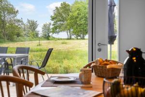 a table with a basket of fruit and a view of a field at LF14344-Roslev-Folvigvej-44 in Roslev