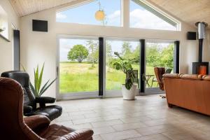 a living room with a couch and chairs and windows at LF14344-Roslev-Folvigvej-44 in Roslev