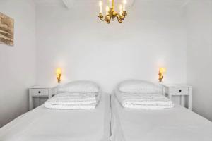 two beds in a bedroom with white walls and a chandelier at LF332-Hurup-Helligsovej-32 in Hurup