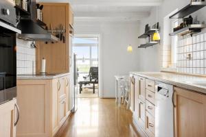 a kitchen with white counters and wooden cabinets at LF332-Hurup-Helligsovej-32 in Hurup +23 photos