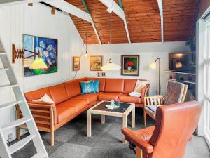 a living room with an orange couch and a table at 0273-Romo-Lyngvejen-63-B in Høm