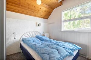 a large bed in a room with a window at 0273-Romo-Lyngvejen-63-B in Høm