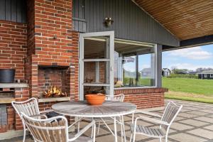 a patio with a table and chairs and a fireplace at LF880-Snedsted-Over-Reese-11 in Snedsted